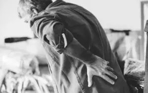 Person holding his back in pain.