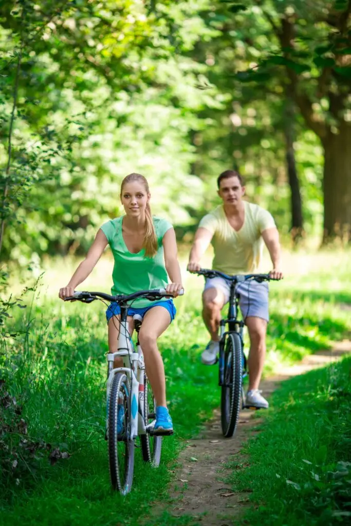 Couple riding a bike | Featured Image for the Exercise and Mental Health Page by Pivotal Motion Physiotherapy