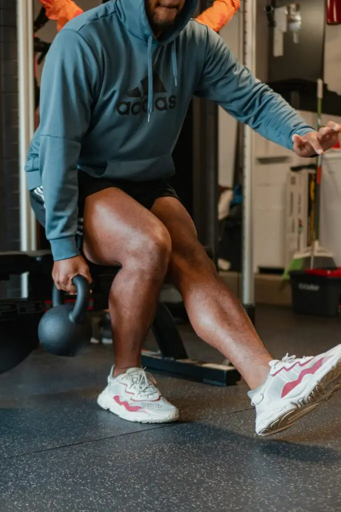 A man using a kettle bell doing leg dips