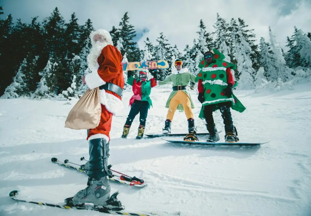 ski players dressed up in christmas costumes while in the snow